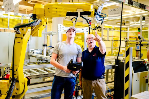 two people working on large piece of equipment