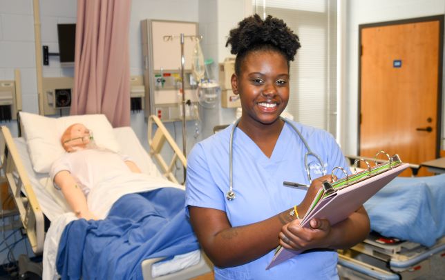 nursing student smiling with pen and pad