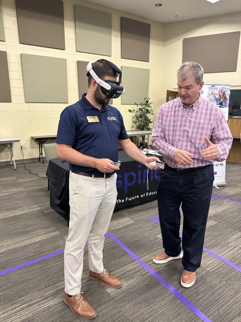 person with VR set on head and someone else helping 